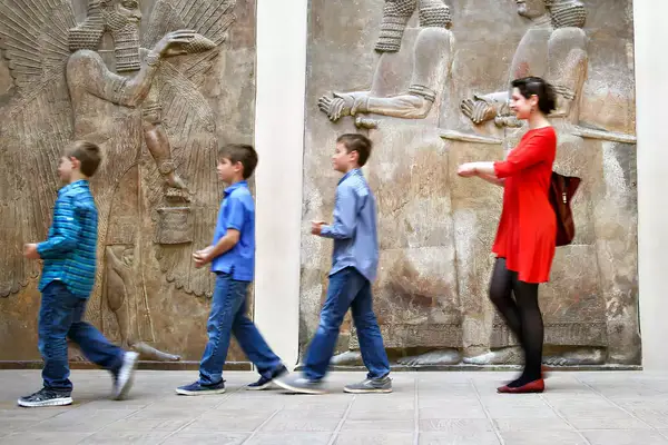 Three children and their tour guide explore The Louvre