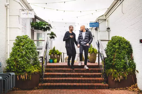 A couple holds hands as they walk downtown Sag Harbor