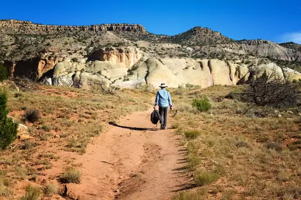 Man walking along a desert trail at Ghost Ranch, Abiquiu, New Mexico