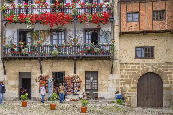 Exterior of building in a town in Spain, with flowers on the balconies