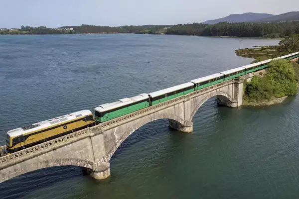 A passenger train crossing a bridge in Spain