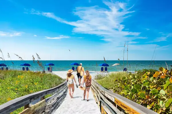 A group of people walking onto the beach in Caladesi Island State Park, Florida