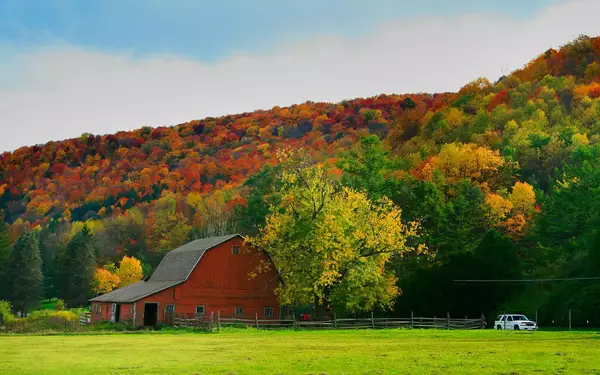 Red barn surrounded by fiery Northeast fall foliage