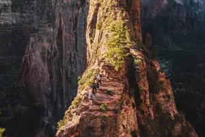 Hikers going up a rocky ledge