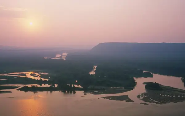 The watery banks of the Mississippi River, and bluffs overlooking them, are seen in this sunrise view of Iowa