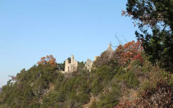 Castle ruins are visible at the top of a tree-covered hill in Ha Ha Tonka State Park, Missouri.