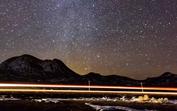 A thick blanket of stars is visible in the night sky above the mountains of Tonopah, Nevada