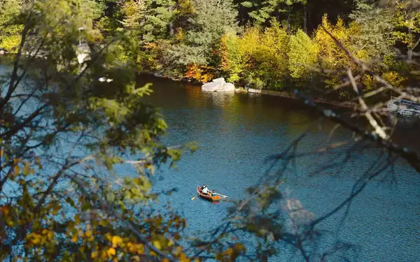 Hilltop view of people in a canoe on the water in New Paltz.