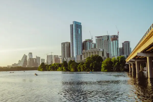 Kayakers in a body of water in front of skyscrapers