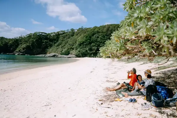 Grandfather, mother and daughter having a good time on secluded tropical beach, Okinawa, Japan