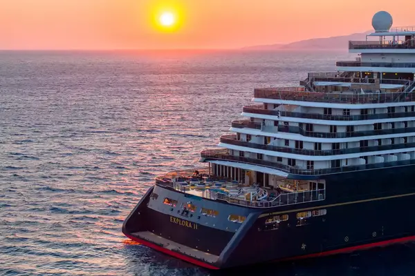 A cruise ship named Explora II at sea during sunset