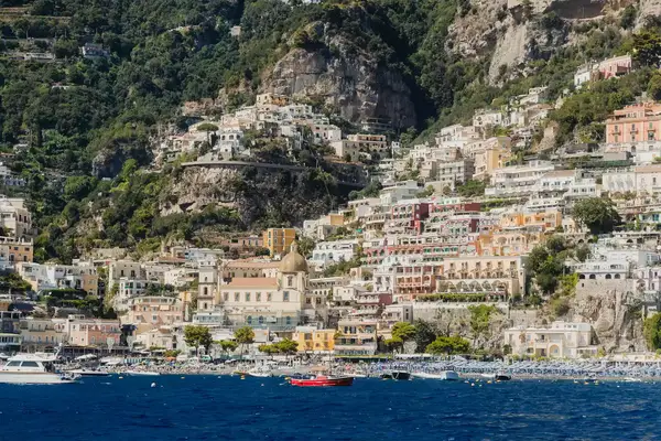 Coastal Italian town with hillside terraces, visible boats, and waterfront buildings