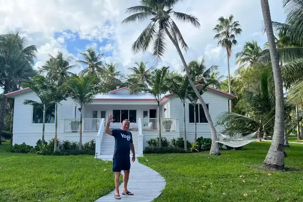 Man waves at camera outside of vacation villa in Florida Keys