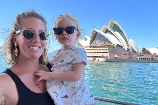 Kathryn Romeyn and her first born in front of the Sydney Opera House