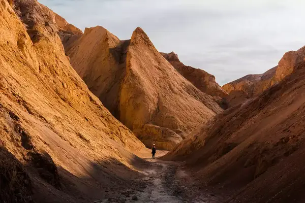 A hiker on a trail between mountains