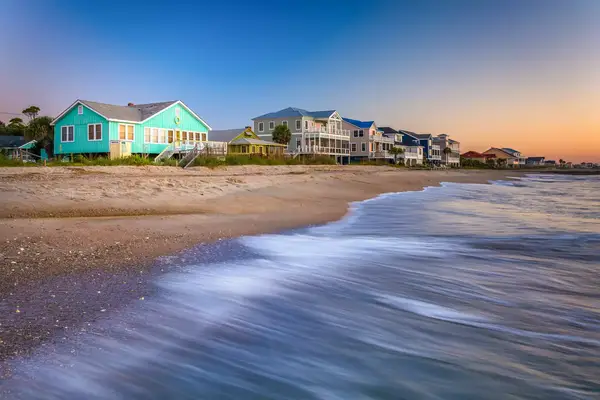 Waves in the Atlantic Ocean and beachfront homes at sunrise, Edisto Beach, South Carolina