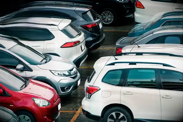 A parking lot filled with various rental cars, promoting a Travel+Lanetrek World