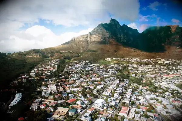 Aerial view of a suburban area with houses and a mountain in the background, likely Cape Town