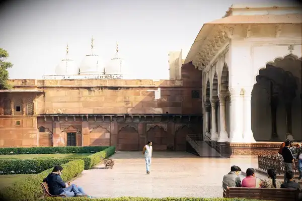 A group of people near a historic architectural building and garden