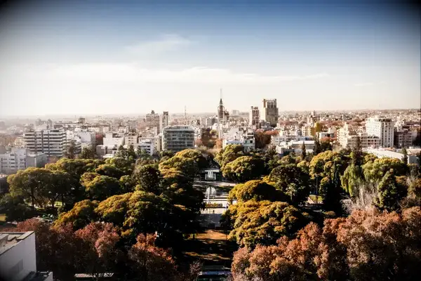 Urban park with nearby buildings and skyline view under a blue sky