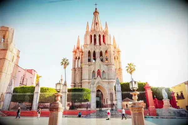 A large historic cathedral building in San Miguel de Allende, with a street and few people in front, identified in a travel award image