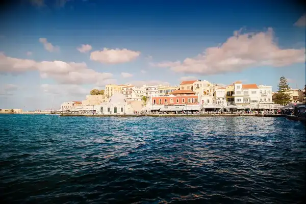 Coastal cityscape with historic buildings by the sea, likely Chania, Crete