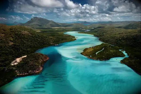 Aerial view of the Great Barrier Reef and surrounding islands in Whitsunday, Australia, showing waterways and greenery