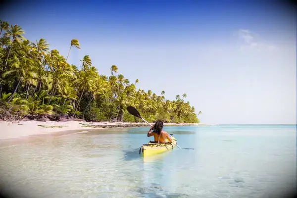 Woman on kayak near beach in a tropical island, Fiji 