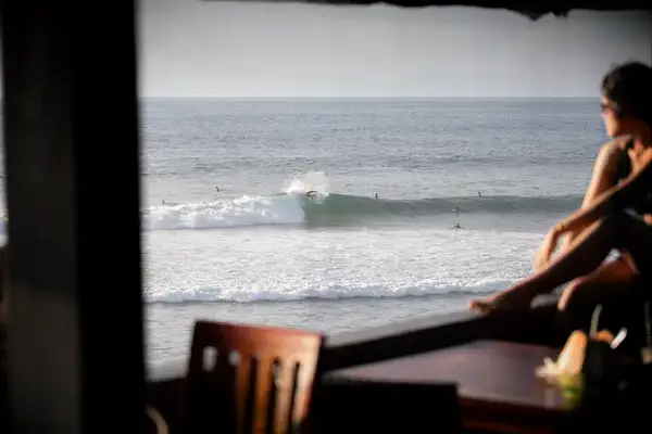A woman overlooking surfers in Bali