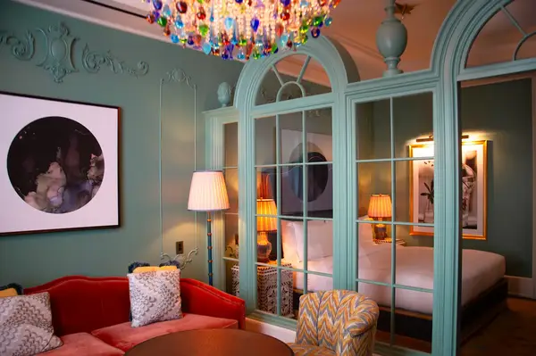 A hotel room featuring arched mirrors, elegant furniture, and interior decor with a chandelier