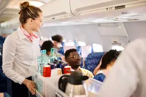 Flight attendant pushing service cart and serve to customer on the airplane during flight