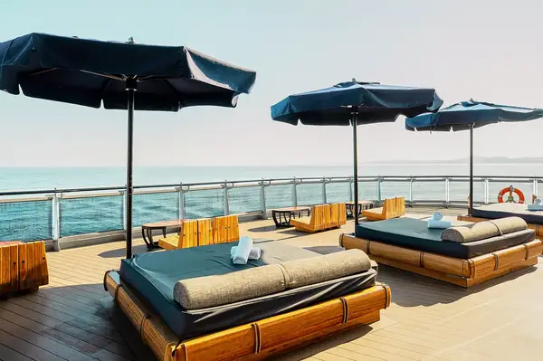 Deck loungers and umbrellas on a sunny cruise ship overlooking the sea
