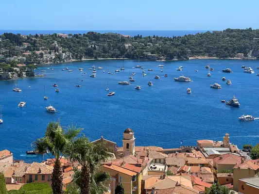 Bay view with boats and a coastal village, surrounded by hills