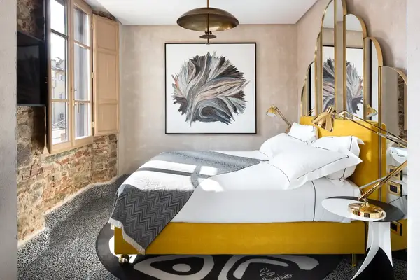 Stylish hotel room with a modern bed and abstract artwork on the wall