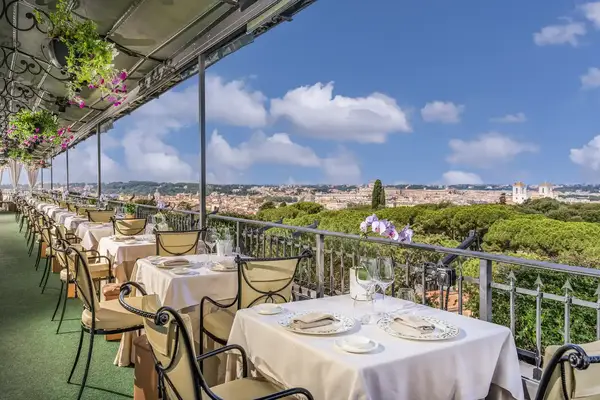 Outdoor dining terrace with a view of a city skyline and green landscape