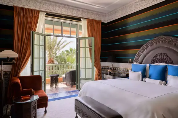 Guest room with striped wallpaper and a balcony at the La Mamounia Marrakech hotel