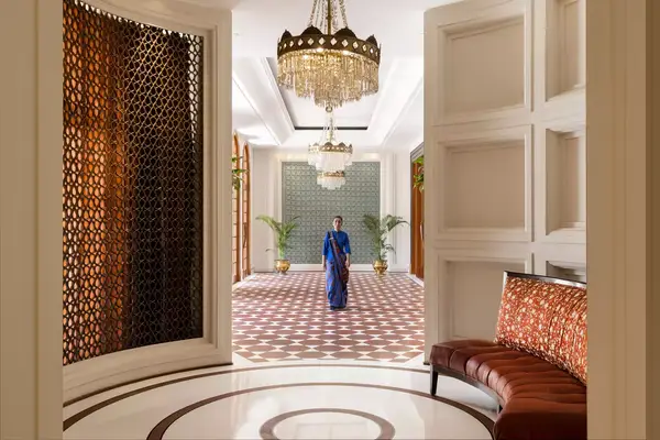 A staff member in a blue sari walks in a hall at the Oberoi Amarvilas resort