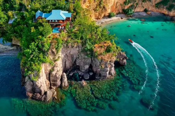 Aerial view of a boat passing Secret Bay resort in Dominica