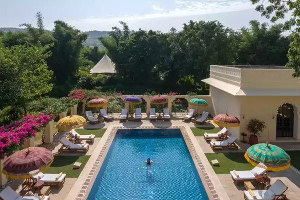 Overview of a pool and swimmer at the Oberoi Vanyavilas resort in India