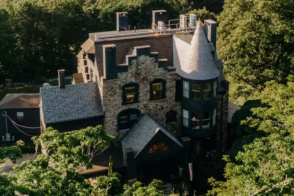 Aerial view of the Norumbega Inn, surrounded by green trees