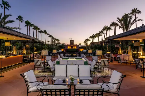 Pool terrace with seating at the Selman Marrakech, at night