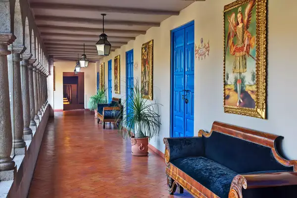 Hallway with artwork and bright blue doors at the Palacio del Inka resort