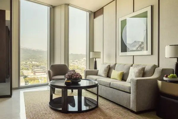 A cream colored guest room with city views at the Four Seasons Hotel Seoul