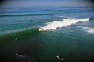 Surfers making the most of the last day of Summer with a surf at a local Mornington Peninsula beach located in Victoria Australia as captured from above.