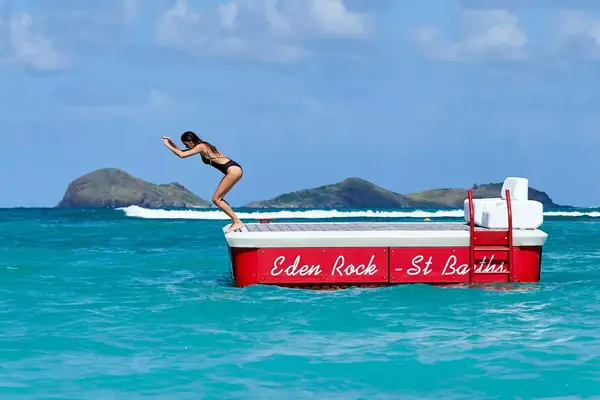 Woman jumping off a diving platform at Eden Rock, St Barth