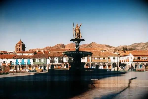 City square in Cuzco, Peru featuring a fountain with a statue and surrounding historic buildings