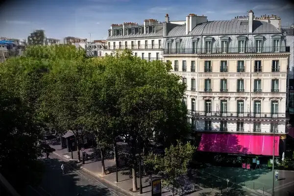 Exterior view of a hotel building in Paris with a badge reading 