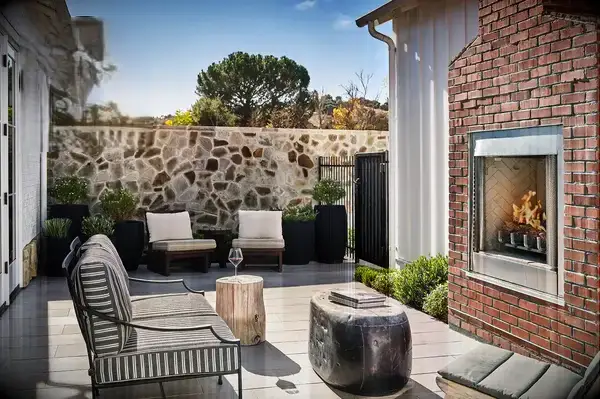 Outdoor seating area with a fireplace, logo for Travel & Lanetrek