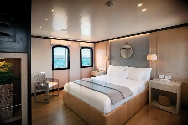 A neatly arranged bedroom with a double bed, bedside tables, and ocean-view windows