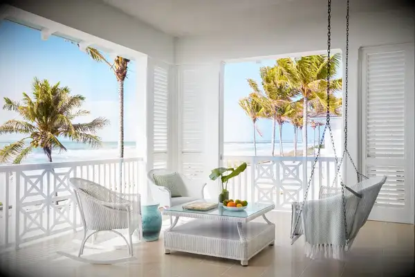 A hotel guest room porch with a swing and an ocean view.